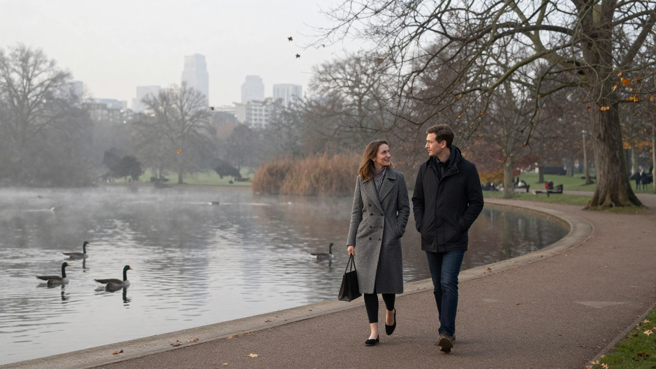 A couple walking calmly along Hyde Park's Serpentine lake at dawn.