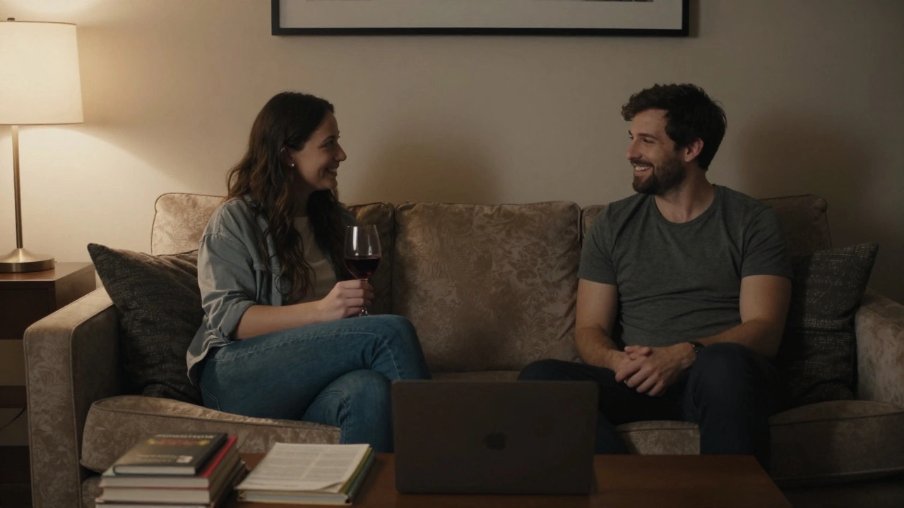Two people sit comfortably on a sofa in a hotel room, sharing wine and conversation.