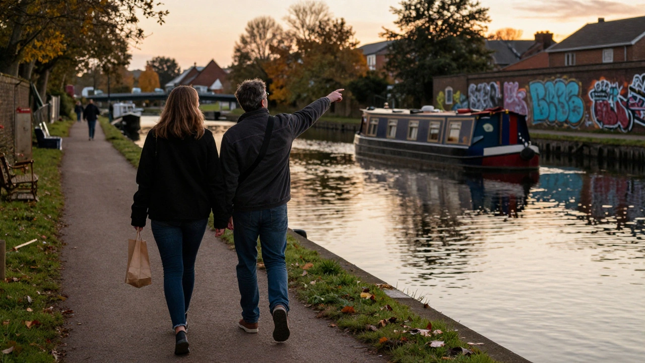 Two individuals walking peacefully along Regent’s Canal at sunset, enjoying the quiet urban landscape.